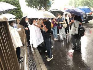 雨の中、入庁行動をとる原告・弁護団と支援者