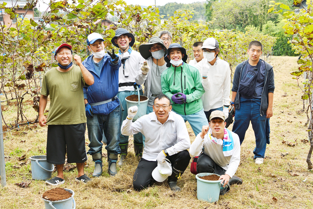 肥料牧作業中の皆さん。笑顔の集合写真