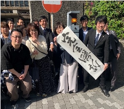 「完全勝利」の幕を掲げる原告団の皆さん