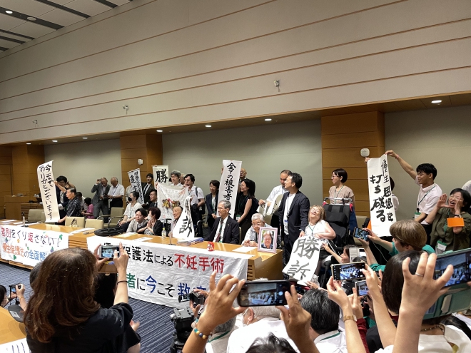勝訴という旗を掲げた原告の方々