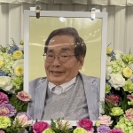 色とりどりの花に囲まれた中西正司さんの遺影