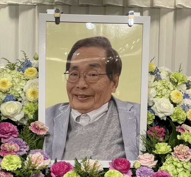 色とりどりの花に囲まれた中西正司さんの遺影