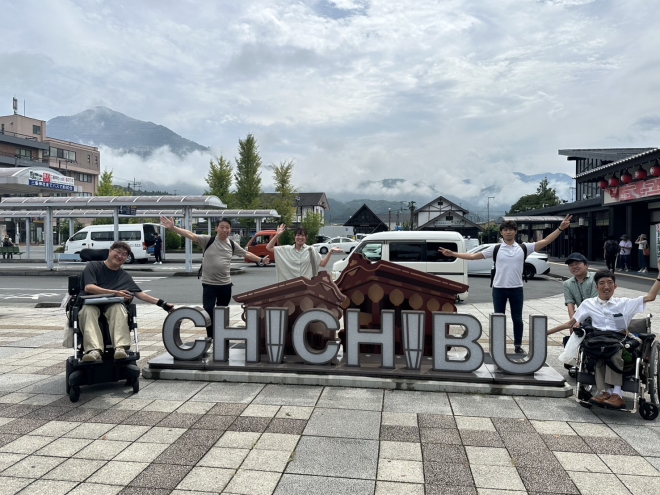写真：西部秩父駅の前の”CHICHIBU”と書かれたモニュメントの前で